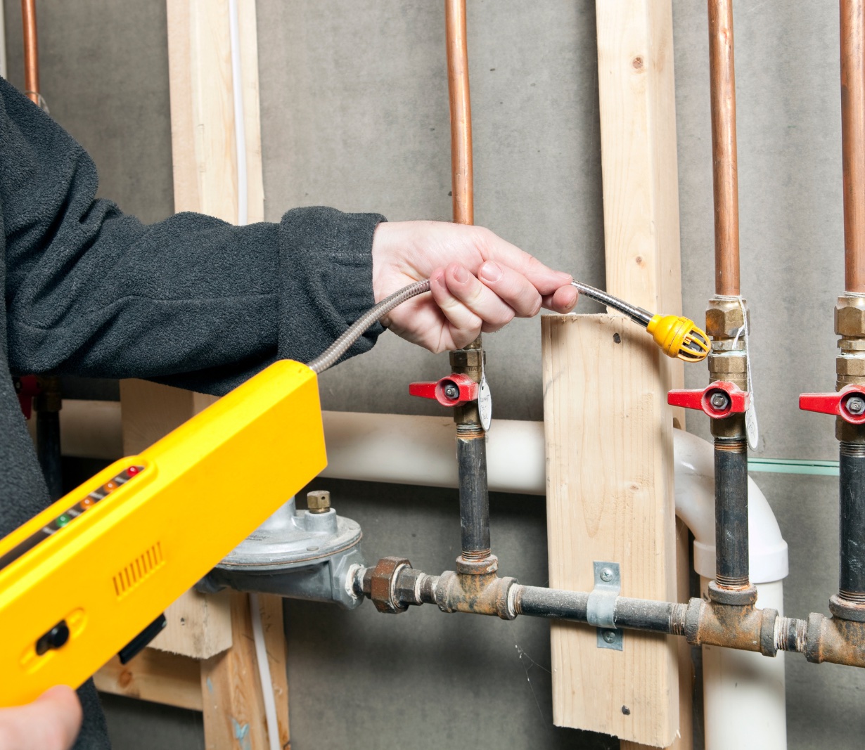 Handheld gas detector checking gas piping and valves